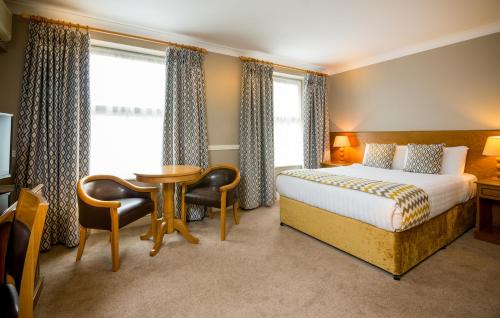 特拉利特拉利贝纳斯酒店的酒店客房带一张床、一张桌子和椅子