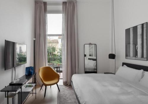 佛罗伦萨BB Hotels Aparthotel Collection Il Michelangelo的酒店的客房 - 带一张床、椅子和窗户