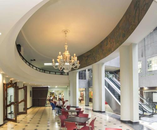 麦德林努提巴拉酒店的一个带桌椅和吊灯的大型大堂