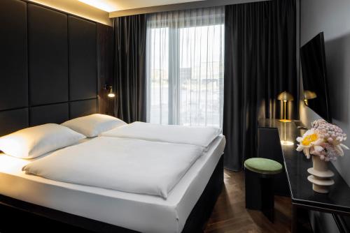 柏林Hotel ROMY by AMANO的卧室设有一张白色大床和一扇窗户。