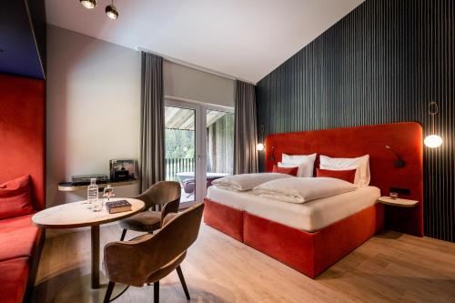 萨尔巴赫Goldstück - Adults Only的酒店客房配有一张床铺和一张桌子。