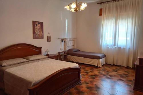 马戈马达斯La Terrazza sul Melograno - Magomadas的一间卧室配有一张床和一把椅子