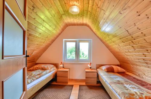 下乌斯奇基Domki nad Stebnikiem的阁楼卧室设有两张床和窗户。
