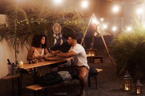 努尔德The Palm Leaf Apartments的坐在野餐桌上的男人和女人