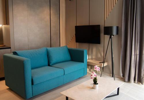 波尔Solis Apartments Bol的客厅配有一张蓝色的沙发,配有一张桌子