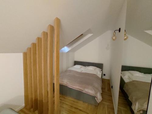 斯图托沃Cicha 3的一间小卧室,配有一张床和一个楼梯箱
