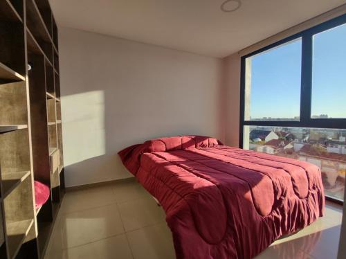 马德普拉塔Frente al mar charlone的一间设有红色床的卧室,位于一个窗户的房间