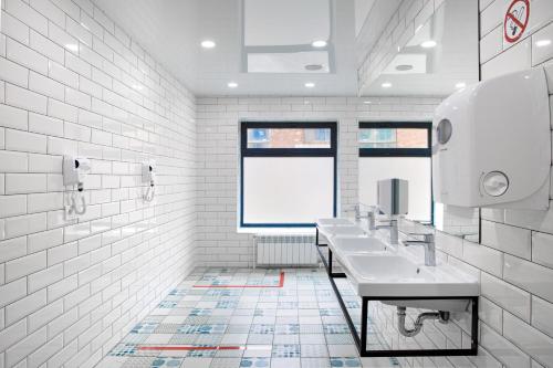符拉迪沃斯托克Luna的白色的浴室设有3个水槽和1个窗户