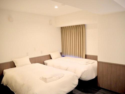 京都圆町车站卓越酒店的酒店客房设有两张床和窗户。