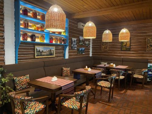 喀尔巴阡Кайзервальд Карпати的餐厅设有木桌和椅子及灯