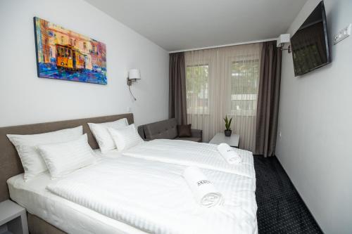 塞格德Arena Deluxe & Spa的卧室配有带毛巾的大型白色床