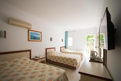 厄吕代尼兹Oludeniz Turquoise Hotel - All Inclusive的酒店客房设有两张床和电视。