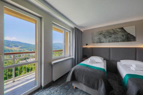 维斯瓦波德杰德拉米酒店的一间卧室设有两张床和大窗户