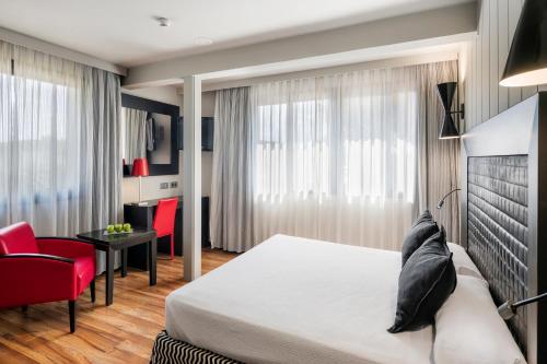 里乌德洛茨·德拉塞尔基瑞纳机场萨勒酒店的一间卧室配有一张床和一张红色椅子