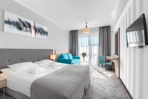 科沃布热格Hotel Leda Spa - Adults Only的酒店客房设有一张大床和一张书桌。
