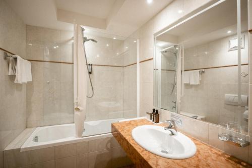 索尔达克里斯塔罗酒店的浴室配有水槽、淋浴和浴缸。