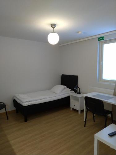 于韦斯屈莱Apartments Käyräkatu的客房设有床、书桌和窗户。