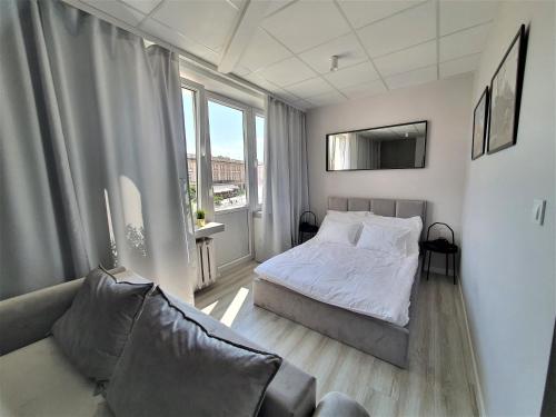 比亚韦斯托克Apartamenty Rynek的一间带床和沙发的小卧室