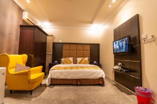 利雅德مقصورة مرسال سويت的酒店客房,配有床和黄色椅子