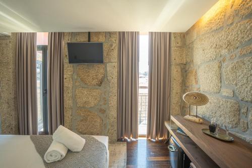 加亚新城CHARM by YoursPorto的酒店客房设有一张床和墙上的电视
