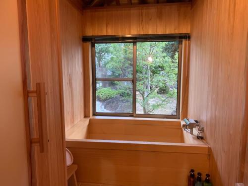 Kasaokaオーベルジュ美の浜 流石的带浴缸的浴室和窗户。