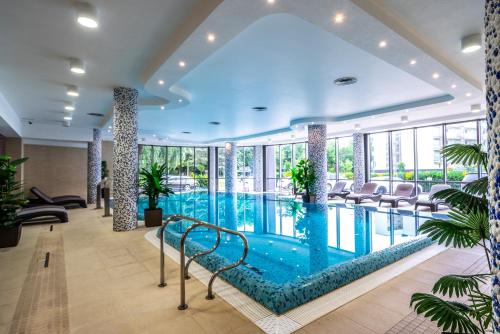 科沃布热格Hotel Leda Spa - Adults Only的酒店大堂设有大型游泳池,设有窗户