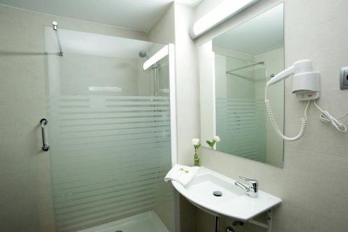 阿尔卡拉德荷那利斯西斯内罗斯酒店的带淋浴、盥洗盆和镜子的浴室