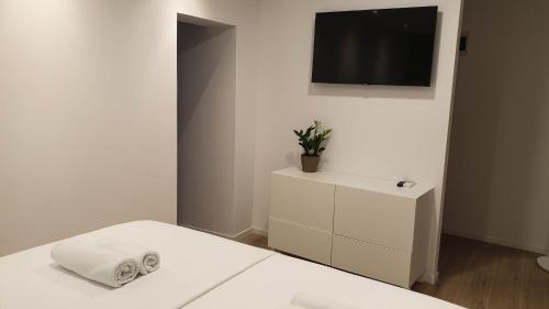 科尔丘拉科尔丘拉菲欧力诺旅馆的一间白色卧室,配有床和电视