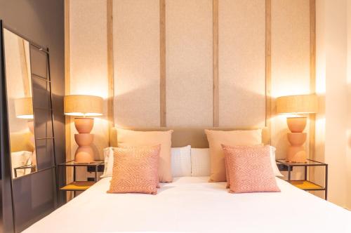 瓦伦西亚Valencia Luxury - Sea Port II的一间卧室配有一张带两盏灯的大型白色床。