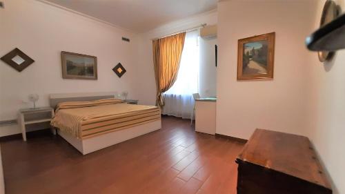 罗马第五住宿加早餐酒店的一间卧室设有一张床和一个窗户,铺有木地板