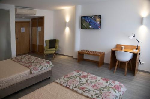 马塞杜-迪卡瓦莱鲁什Hotel Marisol的酒店客房配有一张床、一张桌子和一把椅子。