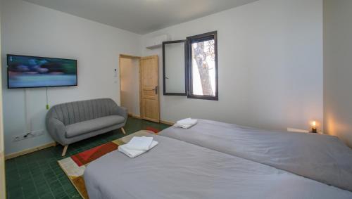 艾格-莫尔特MAS de COLOMINA Aigues-Mortes的一间卧室配有一张大床和一把椅子