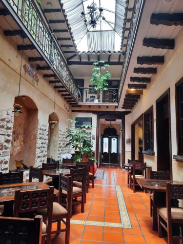 昆卡La Posada Cuencana Hotel Boutique的餐厅设有木桌、椅子和天花板