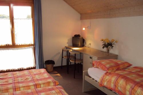 博内夫斯库罗纳餐厅酒店的一间卧室配有两张床和一张书桌及电视