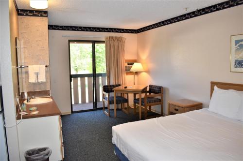 温索普温斯洛普宾馆的配有一张床、一张书桌和一扇窗户的酒店客房