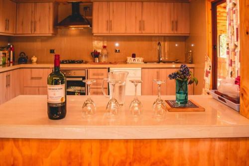 特木科Cunco casa de campo的一瓶葡萄酒,坐在柜台上,配四杯