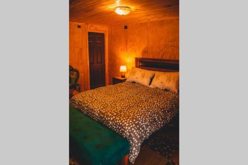 特木科Cunco casa de campo的木制客房内的一间卧室,配有一张床