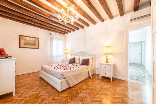 威尼斯Casanova Fenice - Canal View的卧室设有白色的床和木制天花板。