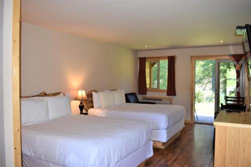 温索普Methow River Lodge的酒店客房设有两张床和一个阳台。