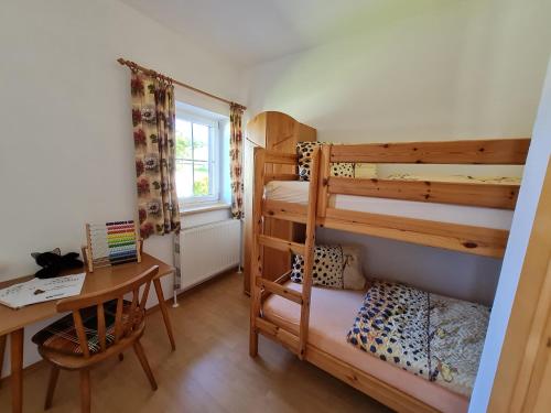 霍夫克什伊姆蒙克爱思古特农家乐的一间卧室配有两张双层床和一张书桌