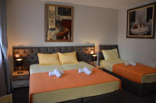 斯科普里Ars Square Apartments的酒店客房设有两张床和两盏灯。