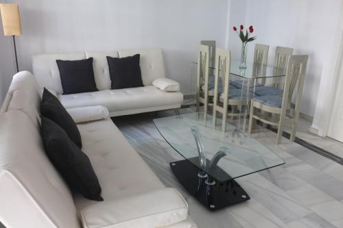多列毛利诺斯Los Colimbos的客厅配有白色沙发和玻璃桌