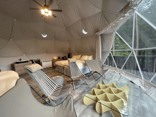 富士河口湖TOCORO. Mt.Fuji CAMP&GLAMPING的带椅子和床的帐篷客房