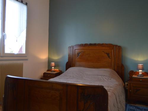 MontipouretGîte Montipouret, 3 pièces, 4 personnes - FR-1-591-190的一间卧室配有一张木床和两个带灯具的床头柜。