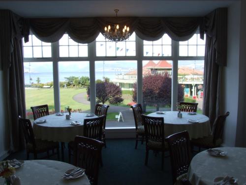 罗撒西维多利亚酒店的一间带两张桌子和大窗户的用餐室