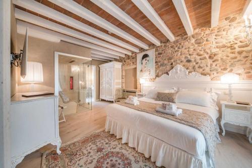 明乔河畔的瓦雷奇奥Regia Rosetta - Royal Rooms Borghetto的一间卧室设有一张大床和石墙