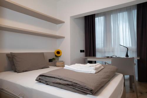 特伦托SILVANELLO Apartment的一间卧室配有一张带白色床单的床和一扇窗户。