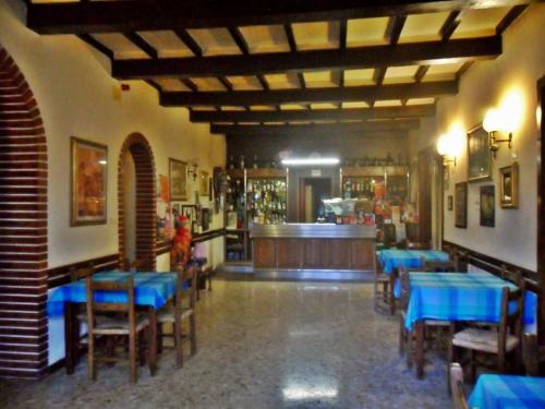 巴迪亚普拉塔基利亚Albergo Giardino的一间设有蓝色桌椅的餐厅和一间酒吧
