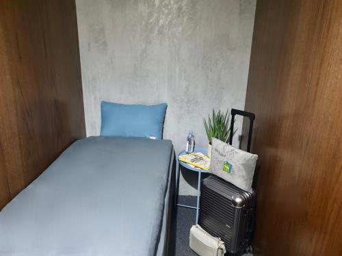 迪拜sleep 'n fly Sleep Lounge & Showers, D-Gates Terminal 1 - TRANSIT ONLY的一间小卧室,配有一张床和一张小桌子
