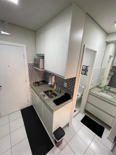 里贝朗普雷托Studio completo e aconchegante的小厨房配有白色橱柜和水槽